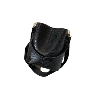 Minimalistische schwarze Krokodil-Beuteltasche mit breitem Gurt und goldenen Details