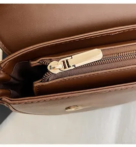Detailed macro view of smooth golden zipper and premium stitching on brown leather bag