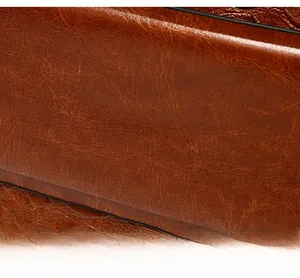 Macro shot of silver metal logo on brown textured leather shoulder bag for women
