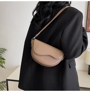 Detailed view of the khaki matte leather saddle bag with smooth curves and logo