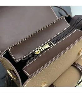 Detail of smooth golden metal zipper and contrast stitching on premium leather bag