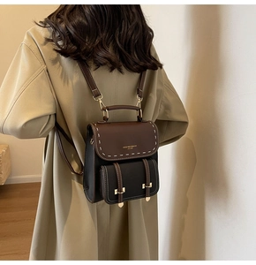 Close-up of contrast color mini backpack with white stitching and gold metal hardware