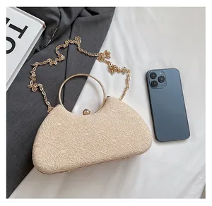 Champagne gold evening clutch with glitter texture shown next to a phone for size reference