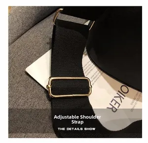 Detail showing adjustable black fabric shoulder strap with premium gold metal buckle