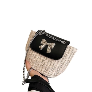 Sac bandoulière en paille avec rabat en cuir noir et décoration nœud argenté
