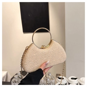 Detail of beige textured evening bag with gold ring handle and metal sphere clasp