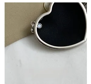 Vue détaillée du sac en forme de cœur avec fermeture magnétique et cadre en métal argenté