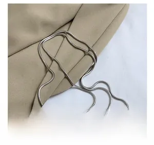 Gros plan d'un sac violet en forme de cœur avec chaîne métallique sur un blazer