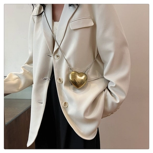Gros plan d'un mini sac doré en forme de cœur avec une finition miroir et une chaîne fine