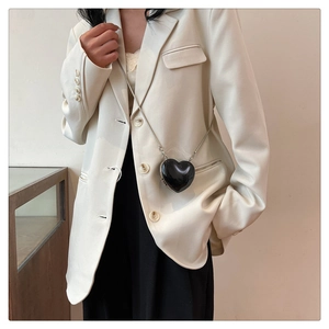Détail du mini sac cœur noir brillant avec sa fine chaîne en métal argenté