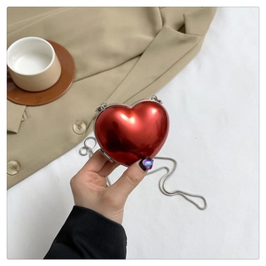Détail d'un mini sac cœur rouge métallisé avec une fine bandoulière chaîne argentée