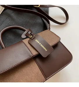 Detail of color-block flap handbag showing premium leather textures and gold hardware