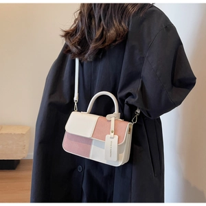 Detailed back view of a color-block crossbody bag in white and dusty rose pink leather