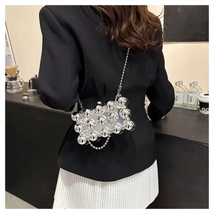 Detail of silver metallic spherical studs and elegant chain strap on shoulder bag