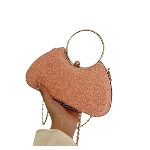 Pink evening clutch bag with round gold metal handle and shimmering woven texture