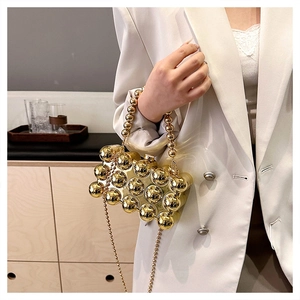Chic gold metallic evening clutch bag with beaded handle and chain shoulder strap