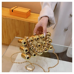 Elegant gold metal ball clutch bag with chain strap for evening parties and dinners