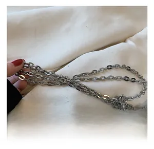 Detailed view of high-polish silver metal chain strap on a women's crossbody bag