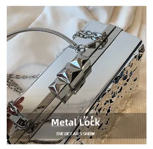 Detailed close-up of the silver acrylic clutch featuring a sleek geometric hardware clasp