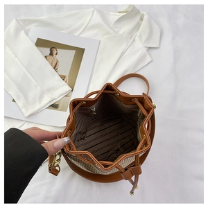 Detail of drawstring bucket bag showing interior lining and woven texture finish