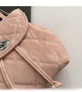 Detail of pink quilted bag showing white contrast stitching and silver twist-lock closure