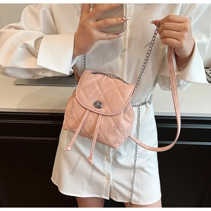 Detail showing the pink quilted mini backpack with silver chain strap and twist lock