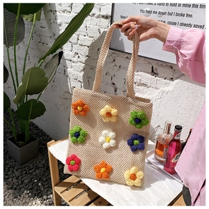 Beige handwoven tote bag featuring colorful 3D crochet floral accents and long handles