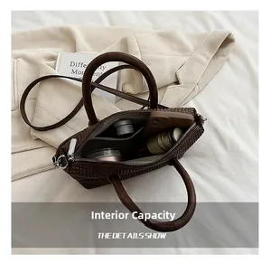 Interior storage view of dark brown woven tote bag showing phone and cosmetics capacity