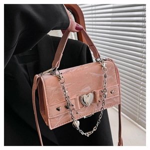 Gros plan du sac en cuir marbré rose avec serrure en cœur et grosse chaîne argentée