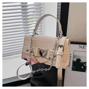 Détail du mini sac carré crème avec boucle métallique en forme de cœur et des rivets