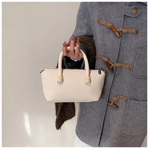 Close-up of beige woven texture tote bag with wooden bead detail on handle
