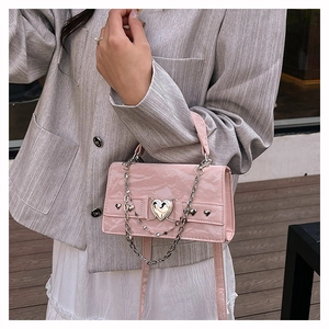 Détail du mini sac carré rose Y2K avec texture plissée brillante et fermoir coeur