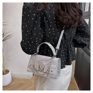 Détail du mini sac en cuir plissé argenté avec fermoir coeur et bandoulière chaîne