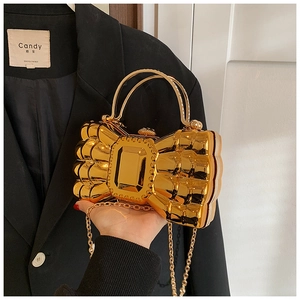 Detail of golden mirror bow evening clutch with crystal gemstone and metal handle