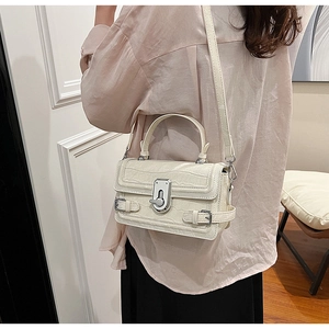 Detailed view of women's off-white crocodile pattern shoulder bag with silver turn-lock