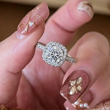Detail of S925 silver halo ring featuring a square pavé border and round center stone