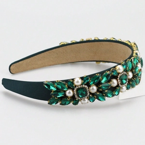 Detailed close-up of emerald green satin headband with pearls and crystal rhinestones