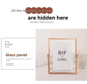Détail d'un cadre rotatif 5x7 en métal or rose avec panneaux en verre sur un bureau