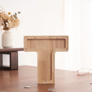 Detalle de hucha de madera en forma de T con panel acrílico y tornillos en escritorio