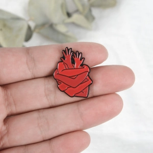 Close-up of red heart hug enamel pin badge made of zinc alloy for clothing decor