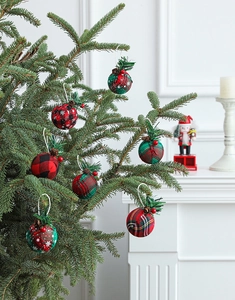 Detailed view of red and green plaid fabric Christmas balls with pine cones and berries