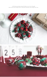 Macro view of plaid Christmas ornaments with pine needles and pine cones on a tray