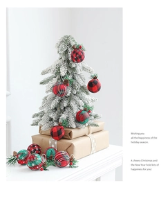 Red and green plaid Christmas balls with pine needles hanging on a white festive tree