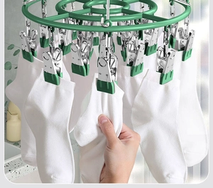 Detailed view of a durable multi-clip green laundry rack drying several white socks