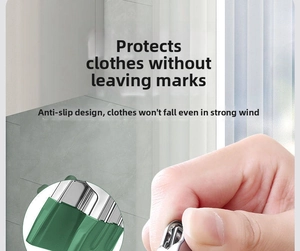 Macro detail of stainless steel clothespin with green non-slip grip pads for clothes protection