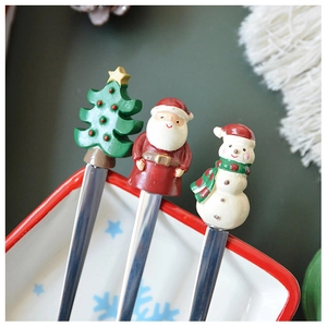 Detail of Christmas themed stainless steel dessert spoons with Santa and Snowman handles