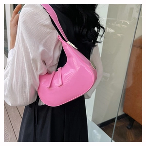 Detailweergave van roze lakleren hobo tas met zilveren gespen en dubbele rits accenten