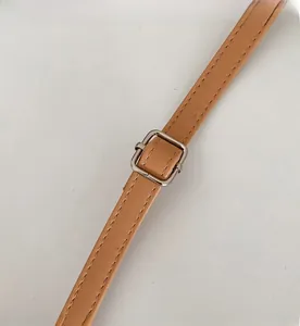 Adjustable brown PU leather shoulder strap with silver buckle and fine stitching detail