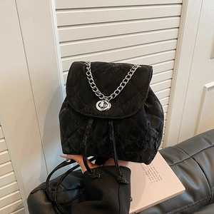 Mini quilted black drawstring backpack with silver chain strap and twist-lock closure