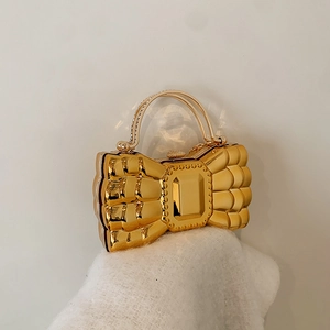 Luxurious gold bow evening clutch bag with rhinestone handle on white knit fabric